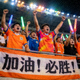 热情球迷穿着球队队服在看台上振臂高呼